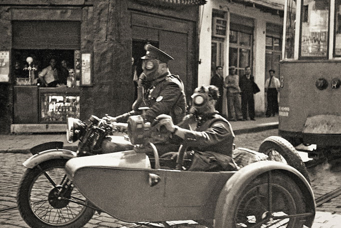 Namık Görgüç/Selahattin Giz: Two soldiers with gas masks in Beyoglu on a basketry motorcycle, Istanbul, 1939. Yapı Kredi Historical Archive